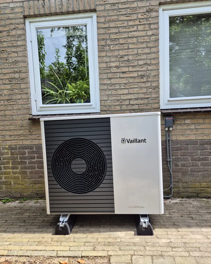 Hybride warmtepomp buitenunit tegen de gevel, geplaatst door MKI-Techniek